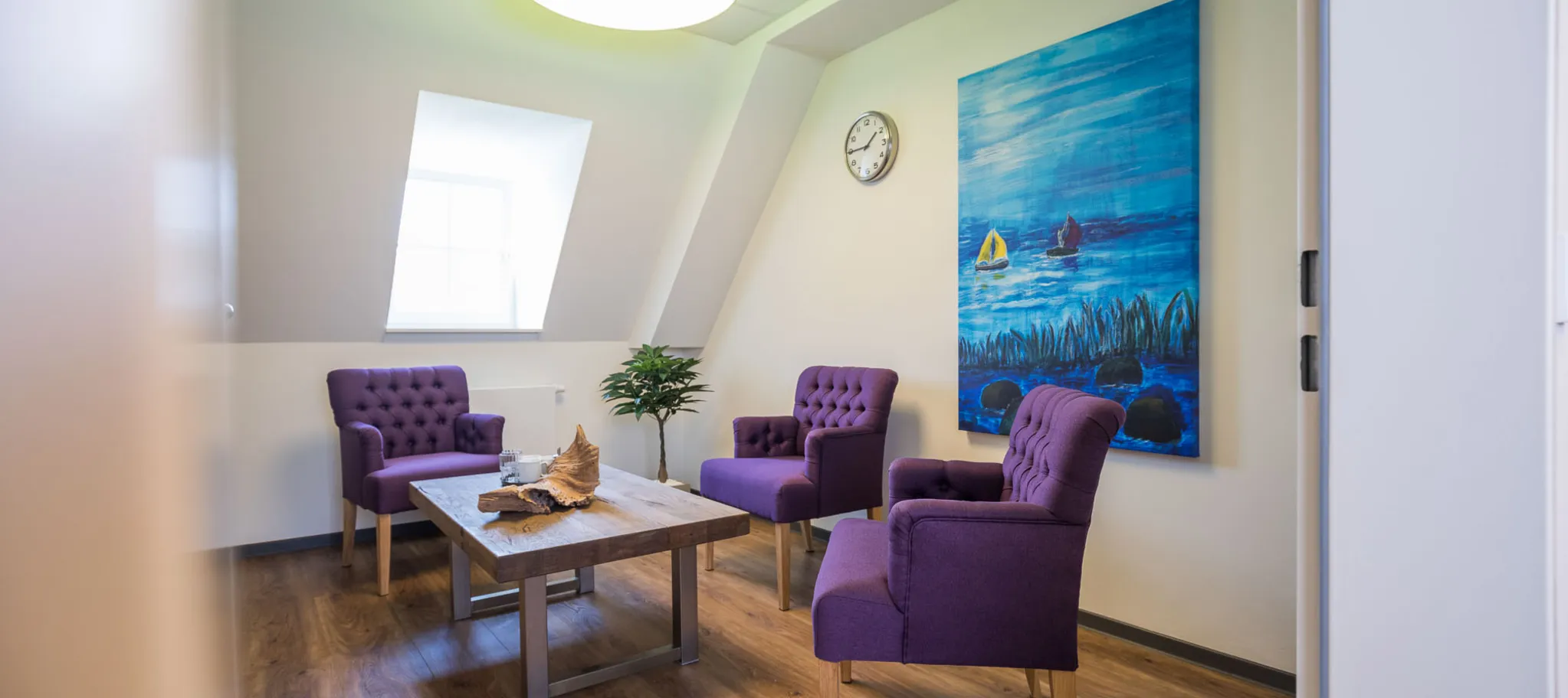 wineo Vinylboden Holzoptik dunkel Wohnbereich Tisch Stuhl Sessel