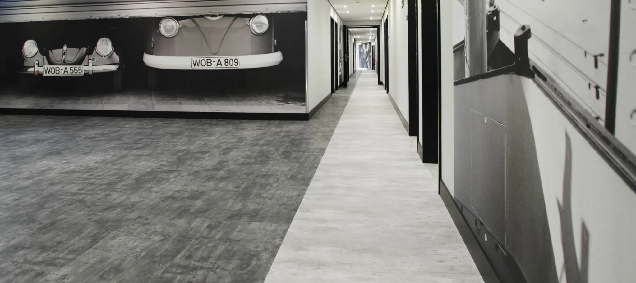 wineo Bodenbelag Steinoptik hell und dunkel im Hotel mit Autos 